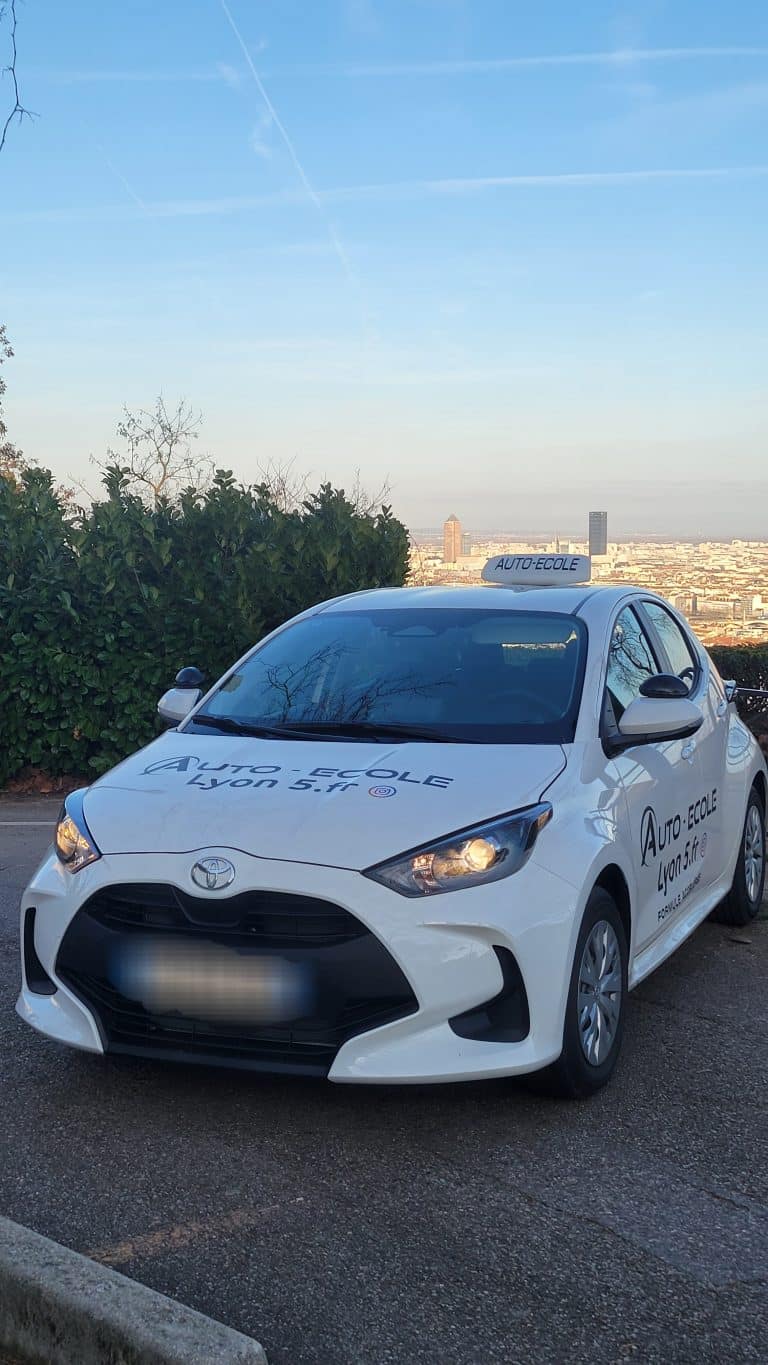 Voiture de l'auto-école Lyon 5ème avec vue sur Lyon